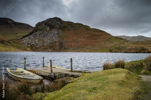 Two dilapidated boats moored at the jetty on Llyn y Dywarchen in the Snowdonia National Park, Wales. photo