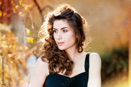 Young woman outdoors portrait. Soft sunny colors on a summer sunny day.