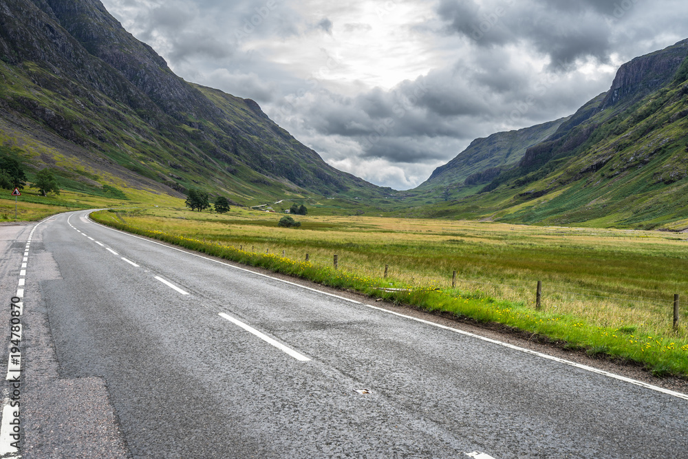 Scenic road in Glencoe valley with dramatic cloudy sky, Highlands, Scotland, Britain