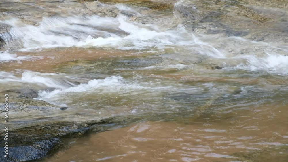 Close up.Pure fresh water waterfall in forest with black rocks. Close up.Pure fresh water waterfall in forest with black rocks.