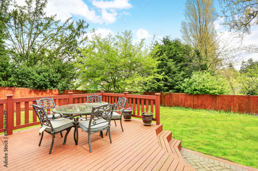 Large deck with dining space overlooking spacious back yard. - obrazy, fototapety, plakaty 