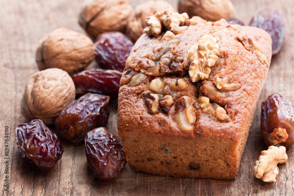 Homemade date and walnut loaf cake on old wooden table Homemade date and walnut loaf cake on old wooden table