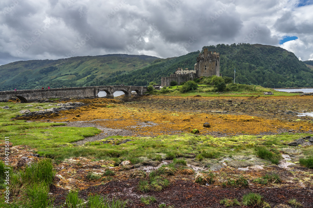 Fototapeta premium Dramatic cloudy landscape with Eilean Donan castle, a famous landmark in Scottish Highlands, Scotland, Britain