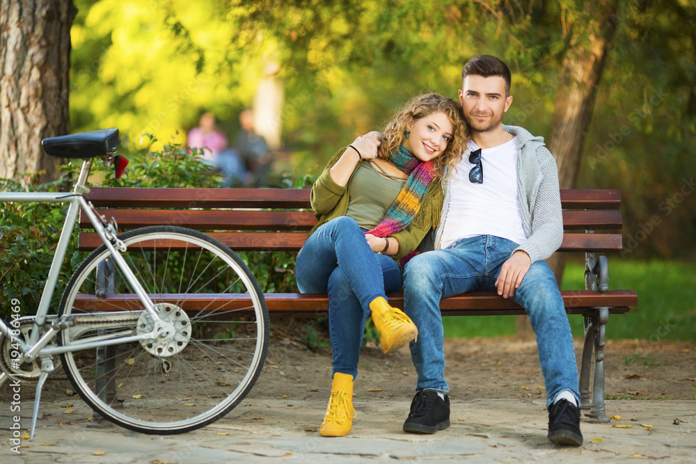 Young couple in park sitting on a bench
