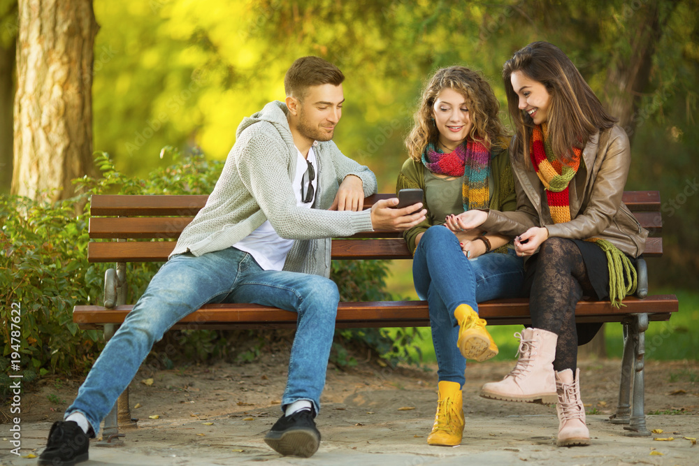Three young people on a bench sitting