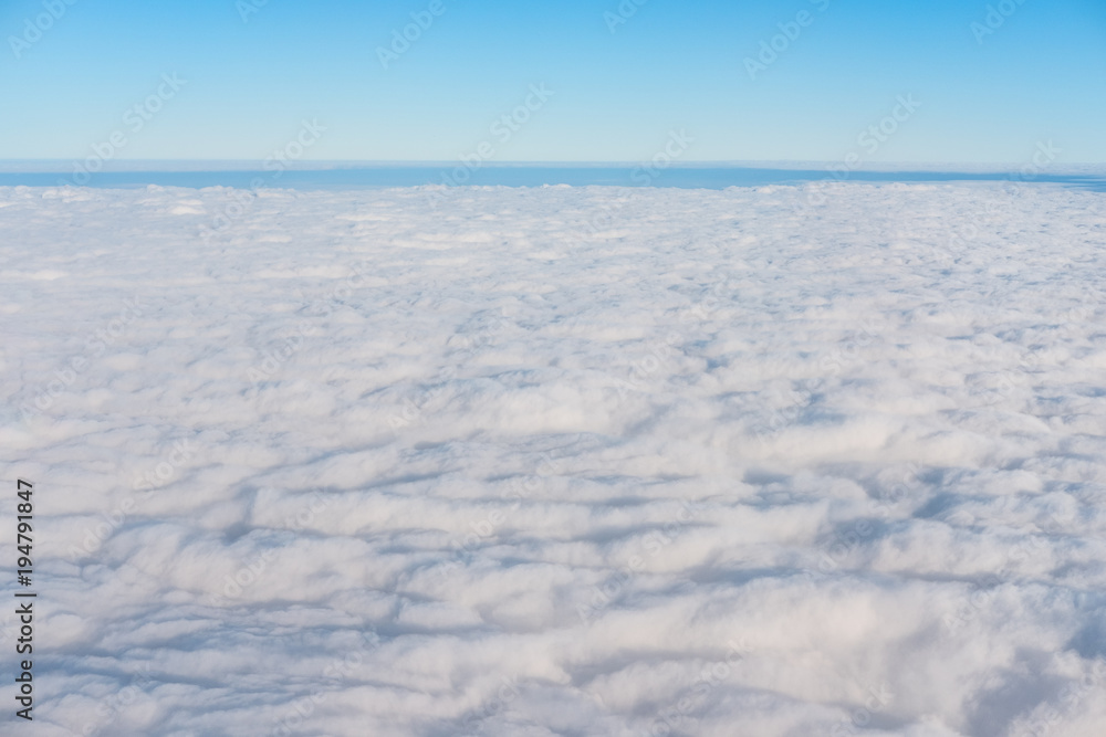 White clouds with blue sky and horizon in beautiful day, above view from air plane