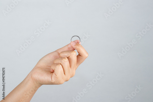  Hand holding a silver ring isolated on white background.