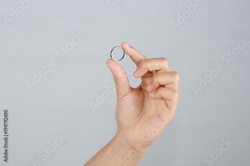 Hand holding a silver ring isolated on white background.