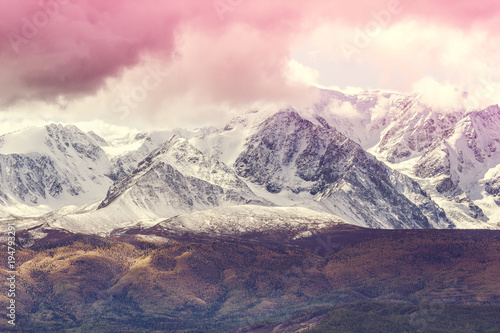 The peaks of the snowy mountain range under the pink sky. Landscape rocks in pastel color.