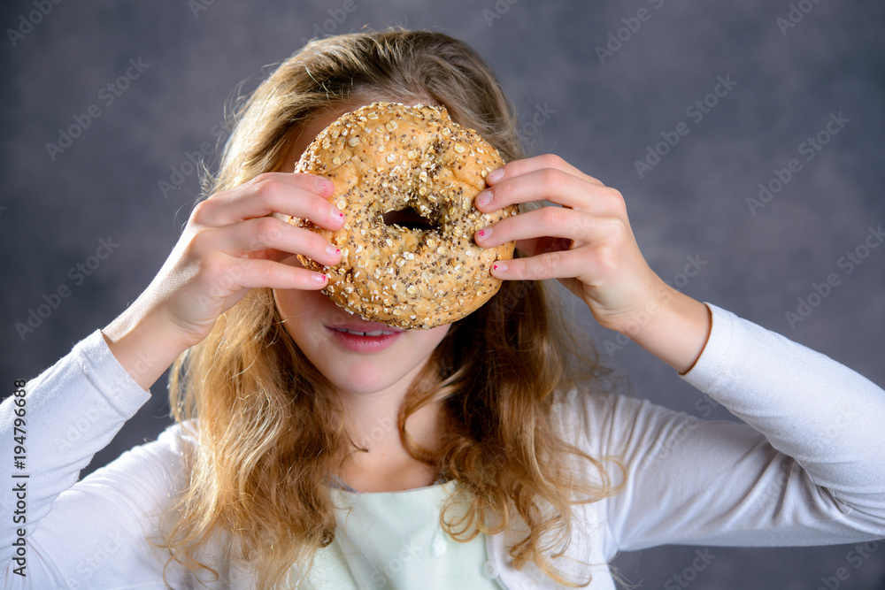 blond girl looking through a big bagel blond girl looking through a big bagel