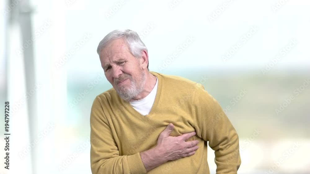 Man having discomfort in chest. Elderly man going taking pills from heart pain. Stress affects the body. Man having discomfort in chest. Elderly man going taking pills from heart pain. Stress affects the body.
