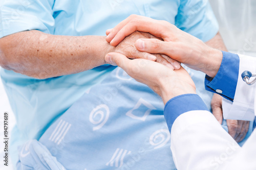Doctor holding elderly person hand with care in hospital.healthcare and medicine