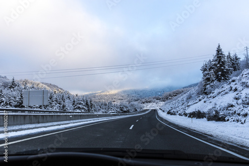 Driving on a road on a snowy landscape and blue sky