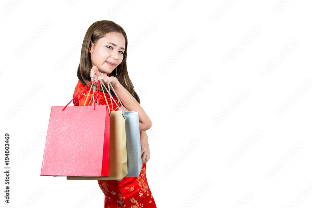 Young and happy smiling asian woman wearing cheongsam holding shopping bags isolated on white background.