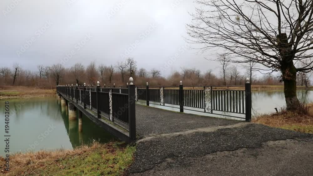Amazing landscape of bridge reflect on surface water of lake, fog evaporate from pond make romantic scene or Beautiful bridge on lake with trees at fog. Iron bridge over lake in misty morning. Slider Amazing landscape of bridge reflect on surface water of lake, fog evaporate from pond make romantic scene or Beautiful bridge on lake with trees at fog. Iron bridge over lake in misty morning. Slider