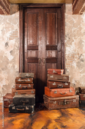 The door and the bag. Vintage used travel suitcases. Many old vintage suitcase. Luggage concept