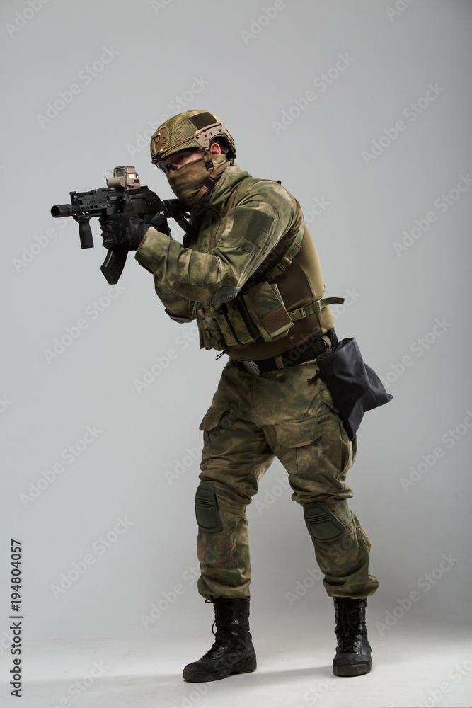 Portrait of full-length military man in camouflage with gun Portrait of full-length military man in camouflage with gun