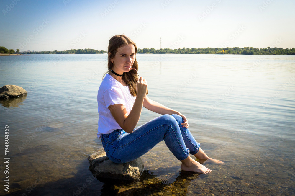 Girl on the stone in the river