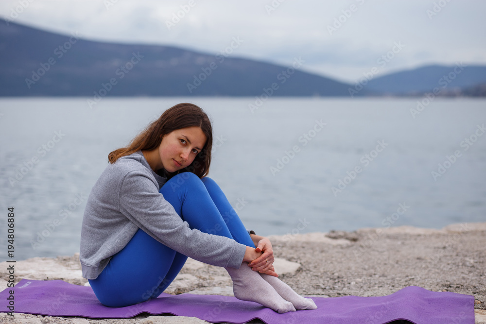 girl doing yoga on the beach
