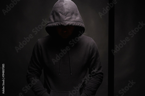 Man in dark, figure in a hooded sweatshirt