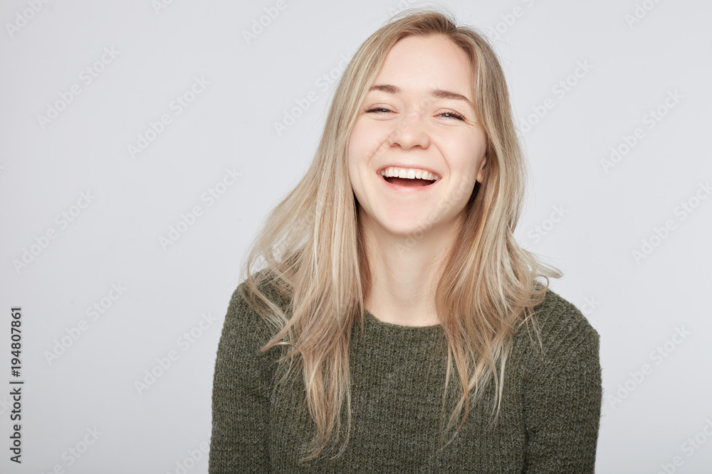 Attractive woman with blond long hair being very glad smiling with broad smile showing perfect teeth having fun indoors. Joyful excited cheery European female rejoicing after being proposed to marry Attractive woman with blond long hair being very glad smiling with broad smile showing perfect teeth having fun indoors. Joyful excited cheery European female rejoicing after being proposed to marry