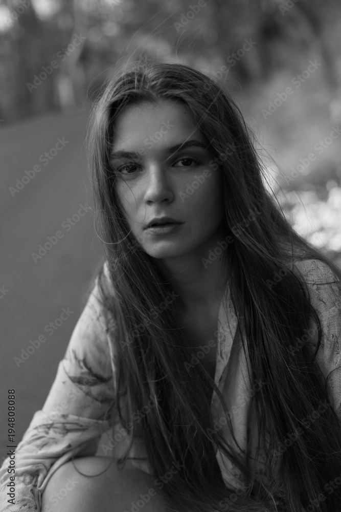 Light my fire. Young beautiful European female model deeply looking at camera, sitting on ground surrounded by burning forest and highway, wearing stylish kimono, hair loose. Fashion, beauty concept. Light my fire. Young beautiful European female model deeply looking at camera, sitting on ground surrounded by burning forest and highway, wearing stylish kimono, hair loose. Fashion, beauty concept.