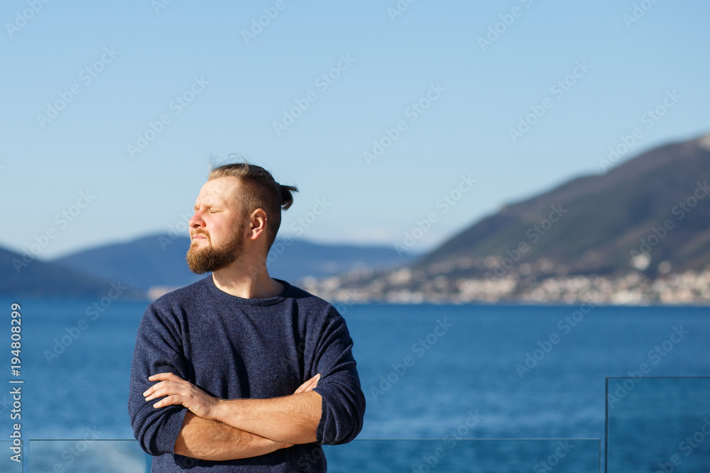 man with a red beard and mustache sea and mountains close-up