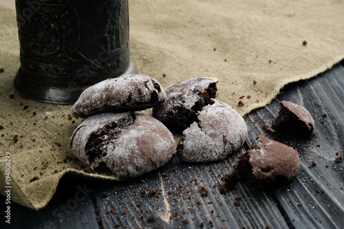 Homemade chocolate cookies on wooden table and textile background
