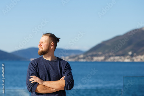 man with a red beard and mustache sea and mountains close-up