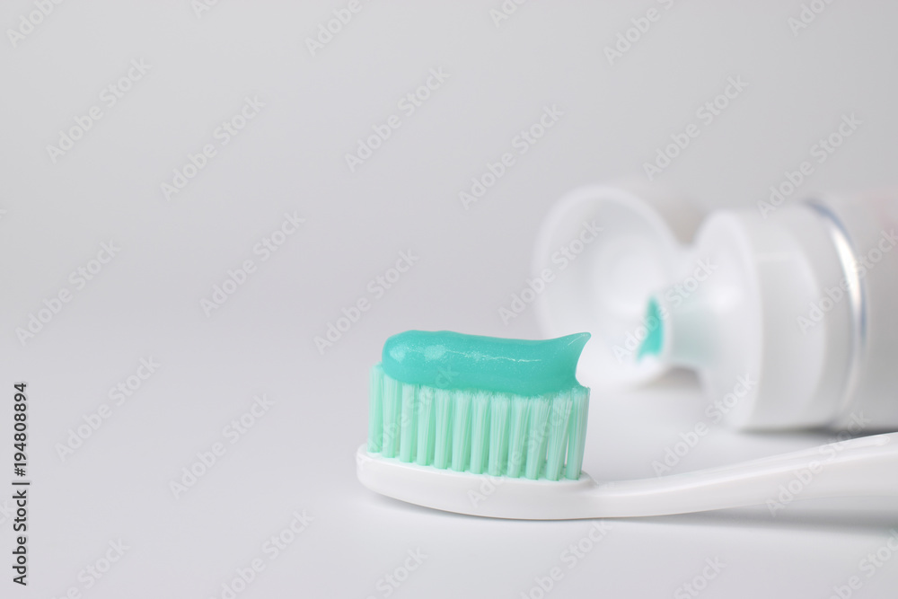 Green toothpaste on a toothbrush on white background Green toothpaste on a toothbrush on white background