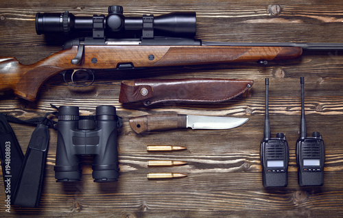 Hunting rifle and ammunition on a wooden background.