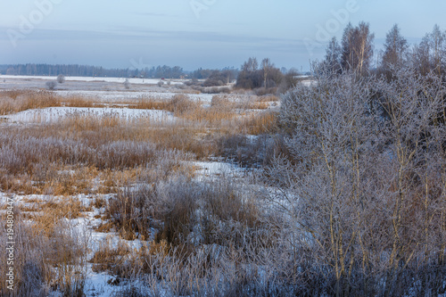 Winter morning, snowy surroundings, cold, frosty. Little river with ice. In some places, the river is not frozen. Winter landscape in the countryside with a small river.
