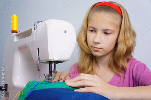 Girl learns to sew on an electric sewing machine