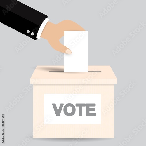 Hand putting a voting ballot in a slot of box