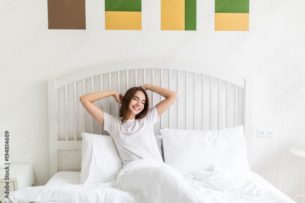 Young woman stretching in bed in the morning Young woman stretching in bed in the morning