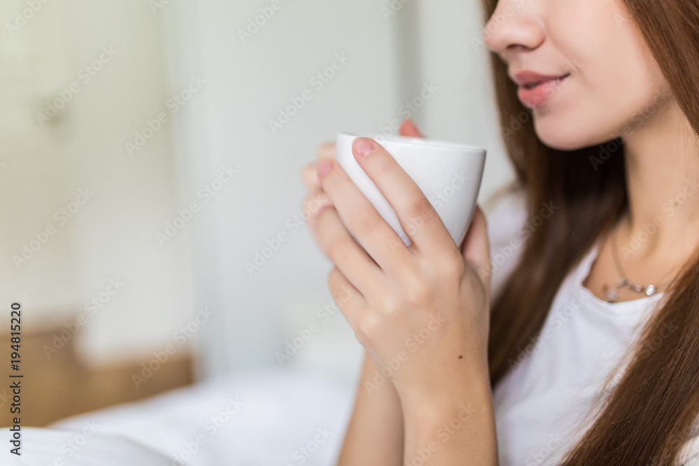 Close up of happy young woman with cup of coffee or cacao and cat in bed at home Close up of happy young woman with cup of coffee or cacao and cat in bed at home