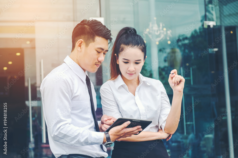 Obraz premium Asian Business couple meeting Using digital tablet outdoor after work