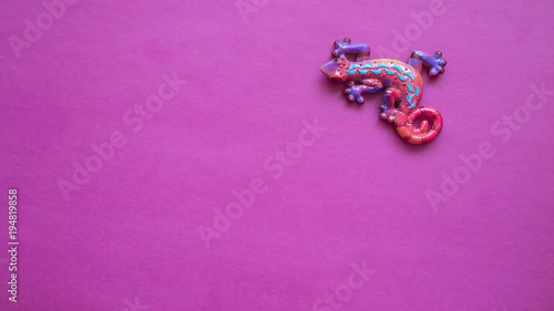 chameleon toy on pink background, copy space