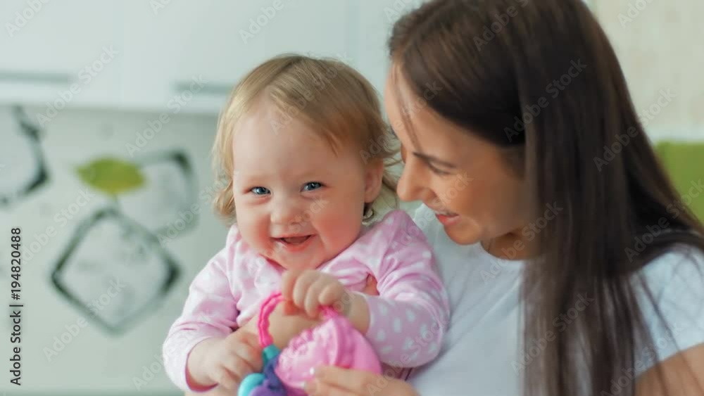 Happy mother and her little cheerful daughter playing at home Happy mother and her little cheerful daughter playing at home
