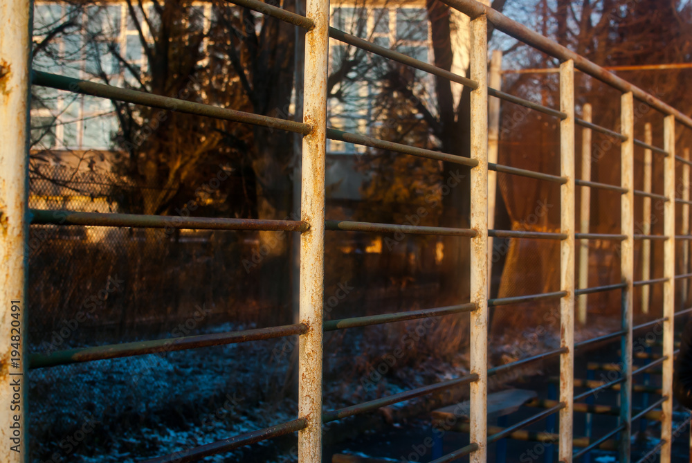The sport ladders on the playground covered with warm yellow light of winter afternoon twilight. 