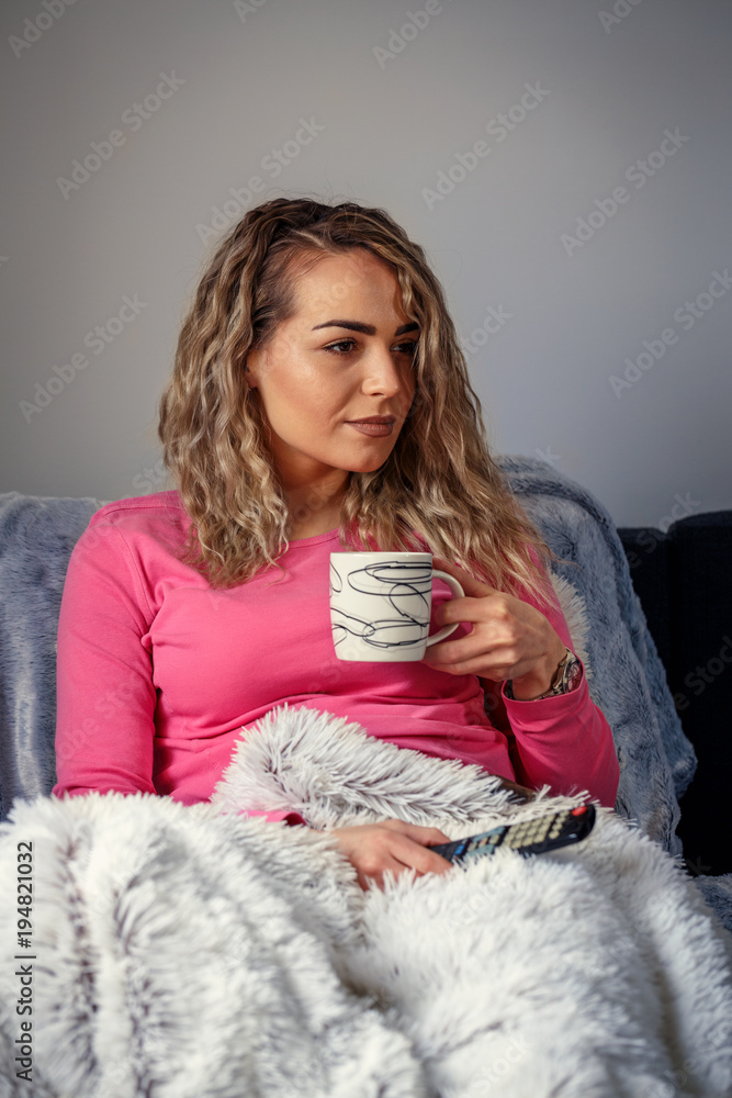 Beautiful girl watching television and drink coffee at home. Beautiful girl watching television and drink coffee at home.