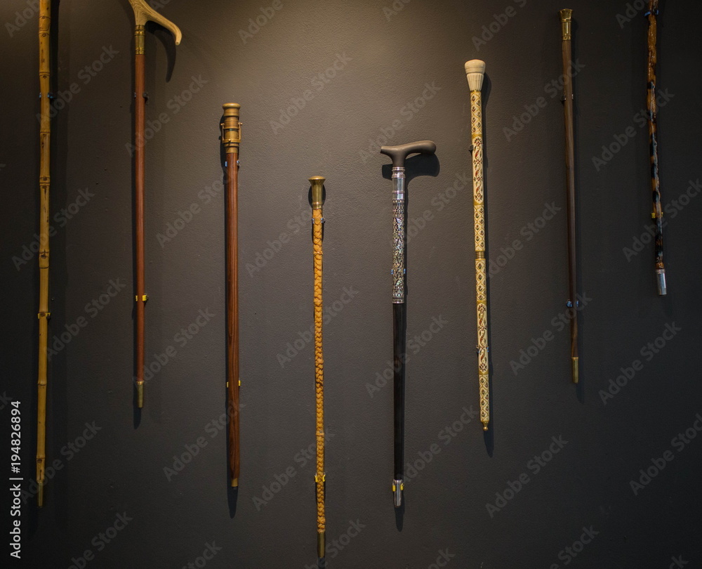 Stockfoto elegant Set of walking sticks and crutches. Telescopic metal canes, wooden cane with