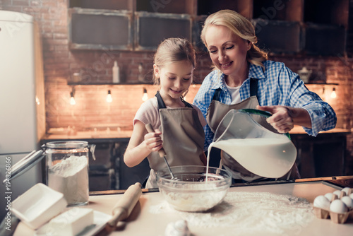 Grandmother and granddaughter cooking on kitchen