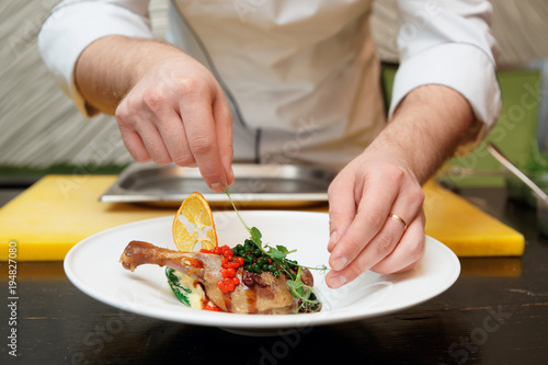 Chef is decorating a dish with herbs