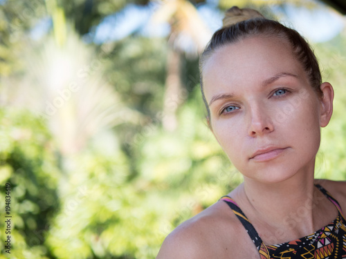 Outdoor closeup portrait of woman over blurred green background