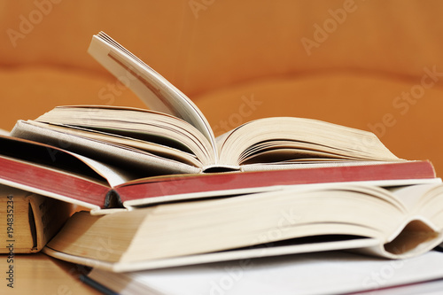 Open books in a hard cover with a blurred orange background