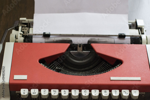Vintage red typewriter with blank paper