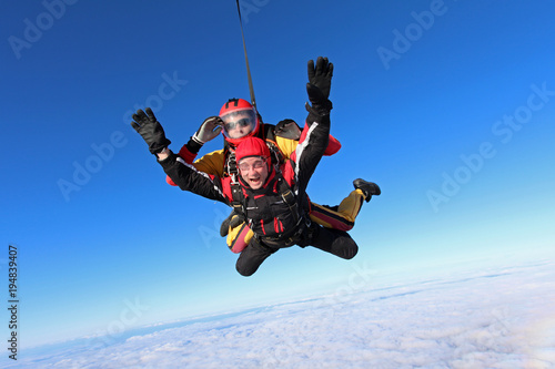 Skydiving. Tandem jump in the blue sky.