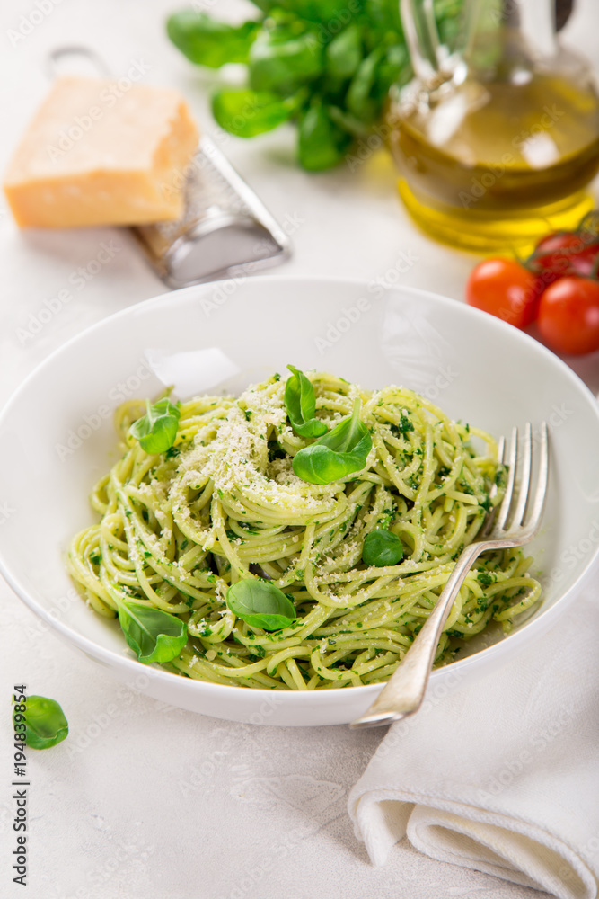 spaghetti pasta with basil pesto sauce and parmesan cheese on white bowl spaghetti pasta with basil pesto sauce and parmesan cheese on white bowl