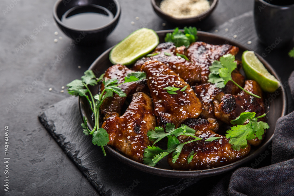 chicken wings roasted with teriyaki sauce, served with lime, cilantro and sesame seeds,